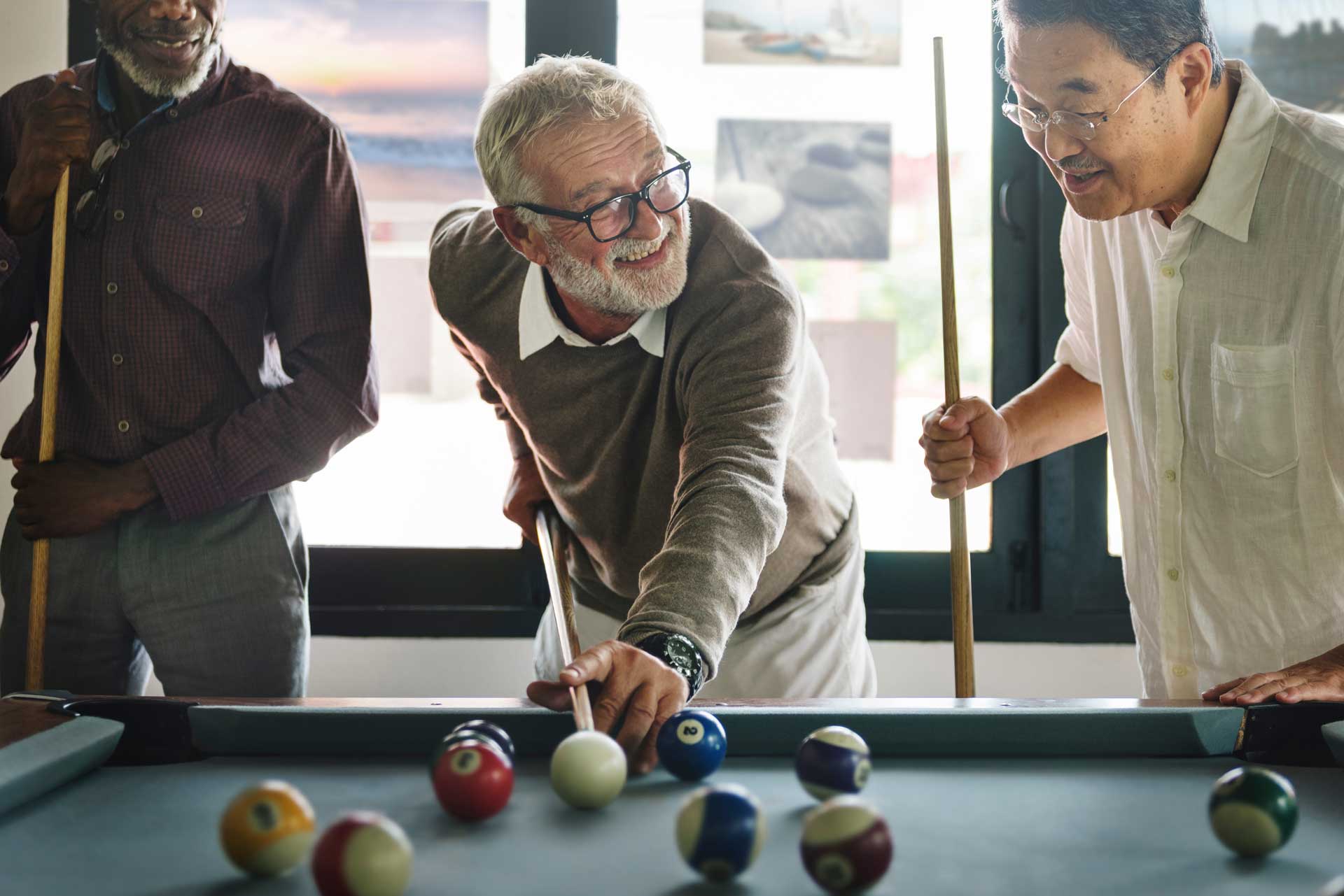 A group of seniors playing pool together